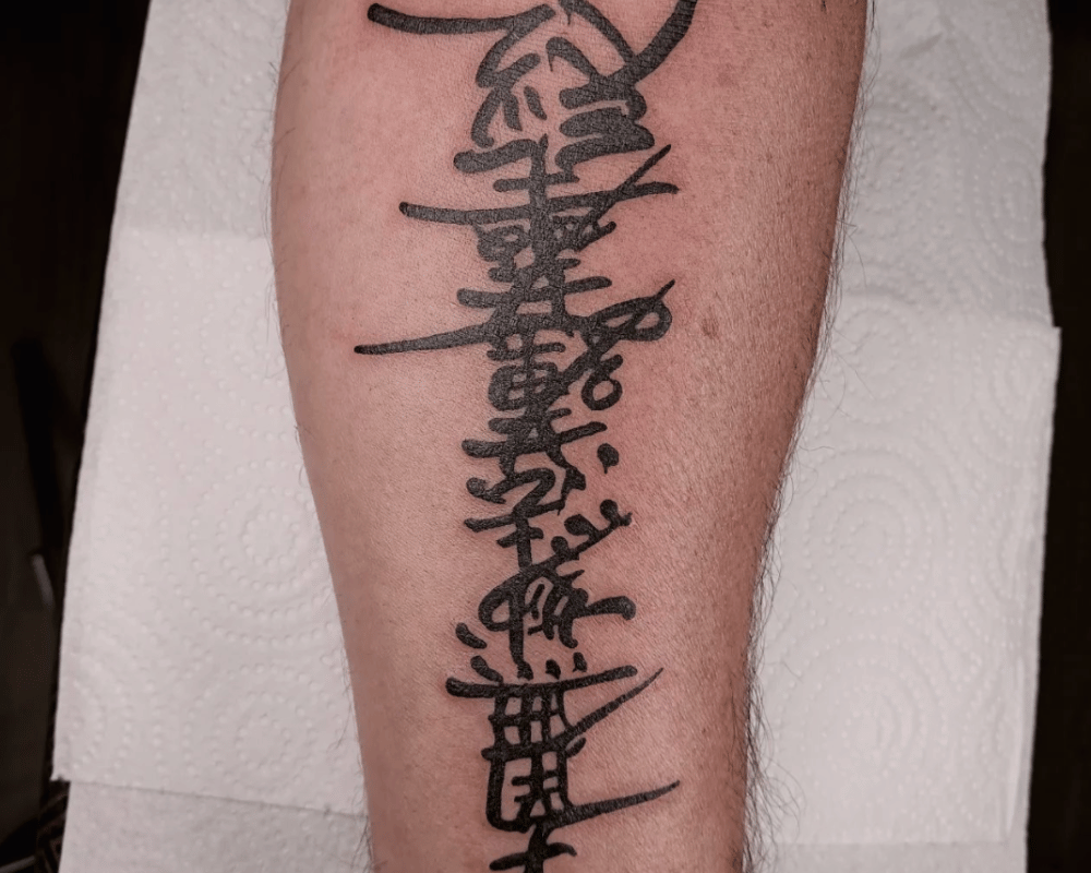 Tatuaje de letras japonesas en estilo black work realizado en DelSandro Tattoo, Santiponce